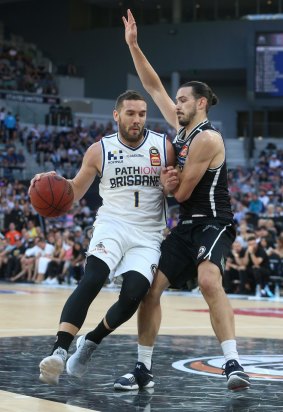 Adam Gibson of Brisbane drives on Chris Goulding of Melbourne United.