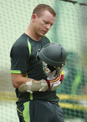 Ruled out: Chris Rogers of Australia looks at his helmet after being struck while batting during an Australian net session in Dominica. The blow resulted in him being ruled out of the Test. 