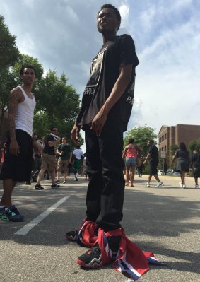 An anti-Klan demonstrator wears shreds of the Confederate flag on his feet.