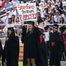 Graduating student Andrea Lorei, who helped organise campus demonstrations following the Brock Turner case, holds a sign in protest before the 125th Stanford University commencement ceremony in June. 
