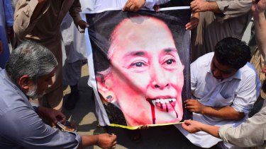Pakistani protesters burn a caricature of Aung San Suu Kyi in a protest against ongoing violence against the Rohingya Muslim minority in Myanmar.