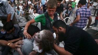 Men hold an injured girl rescued from a site hit by what activists said was heavy shelling by regime forces in the Douma district of Damascus.
 