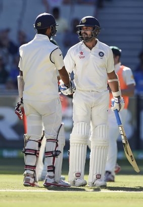 India opener Murali Vijay (right) is congratulated by partner Cheteshwar Pujara on reaching his half-century against Australia late on day two of the Boxing Day Test at the MCG.