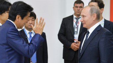 Mr Abe speaks to Mr Putin at the forum.