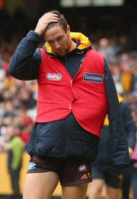James Frawley of the Hawks walks around the boundary line in the sub's vest after injuring his shoulder.