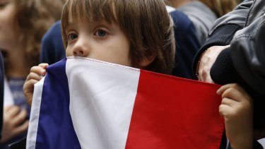 A boy holds a French flag during a vigil in Paris.