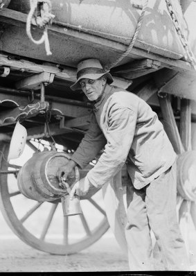 Man filling a mug from a barrel on a bullock team's wagon, New South Wales, 1 October 1933.