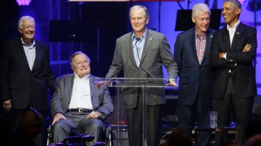 Former US president George W. Bush, centre, speaks as from right, Barack Obama, Bill Clinton, George HW Bush and Jimmy Carter look on during a hurricanes relief concert in Texas on Saturday.