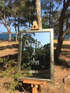 A mirrored sign welcomes guests to the wedding.