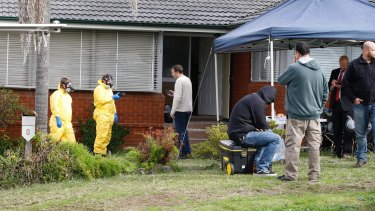 Police search a house in Georges Hall after a drug raid on Wednesday. 