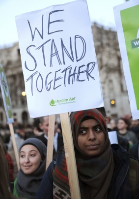 A woman holds up a placard during a candlelit vigil at Trafalgar Square on March 23.