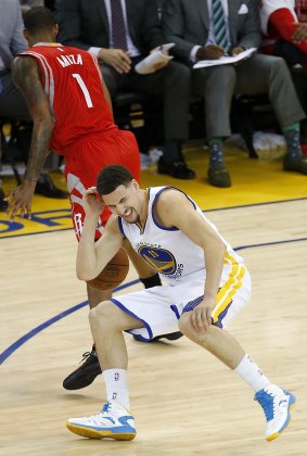 Painful blow: Golden State Warriors guard Klay Thompson reacts after taking a knee to his head from Houston Rockets forward Trevor Ariza.