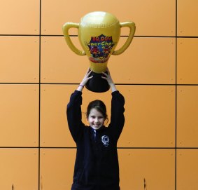 Abigail Mangin,12, celebrates the school's win with a trophy from Skoolbo. 