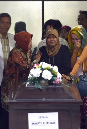 Relatives of Hayati Lutfiah Hamid cry upon receiving her remains at the police hospital in Surabaya. 