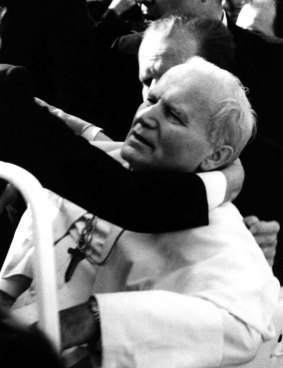Pope John Paul II lies seriously wounded in his open car moments after he was shot by Mehmet Ali Agca in St Peter's Square on May 13, 1981.