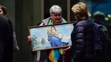 Julie Cameron holds a painting of the Virgin Mary and child outside the Melbourne Magistrates Cout.