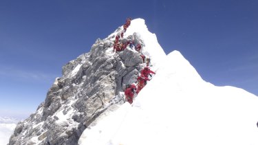 A conga line of climbers approaches the congested Hillary Step after reaching the summit of Mount Everest. 