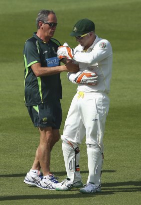 Injured: Brad Haddin receives attention during the first session before leaving the field.