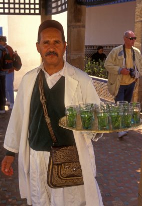 Waiter with a tray of refreshing mint tea at Cafe Maure.