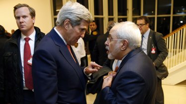 US Secretary of State John Kerry talks with Iranian Foreign Minister Mohammad Javad Zarif, right, after the IAEA verified that Iran has met all conditions under the nuclear deal.