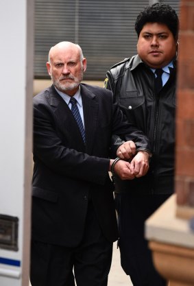 Ian Macdonald is led to the prison truck after being sentenced to a maximum of 10 years in jail.