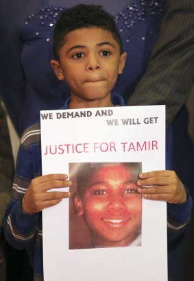 A boy holds a sign demanding action after 12-year-old Tamir Rice was fatally shot by police in Cleveland, Ohio, in November 2014.