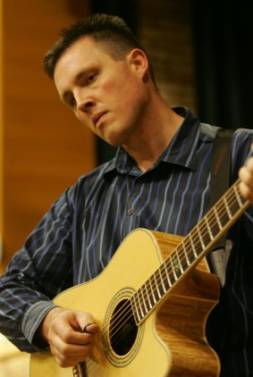 Lorin Nicholson performs on accoustic guitar.