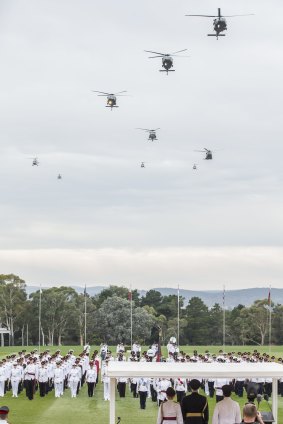 Australian Defence Force Academy year one officer cadets and midshipmen parade as the army and navy helicopters fly past.  

