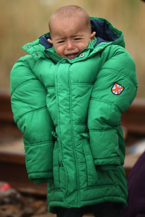 A boy cries as he walks towards waiting buses at the Hungarian border with Serbia.