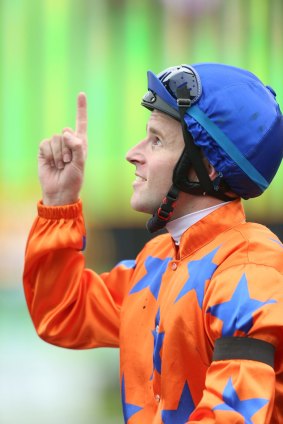 Jockey Tommy Berry points to the heavens in memory of Canberra track rider Riharna Thomson after riding Canberra horse Rocket Commander to victory in the Wenona Girl Quality.
