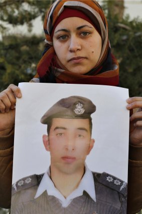 Anwar Tarawneh, wife of Muath al-Kasasbeh, holds a picture of him at a rally calling for his release.