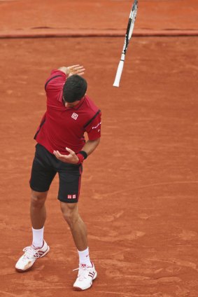 Djokovic throws his racket, narrowly missing a linesman.