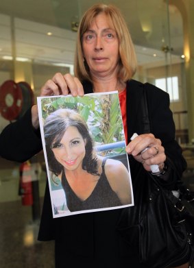 Louise Miller holds a photo of her sister, victim Catherine Pracy.