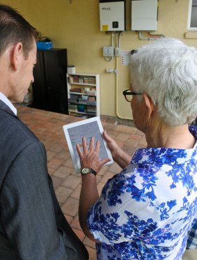 Lainie sjhowing Shane Rattenbury MLA the real-time solar battery system data. 