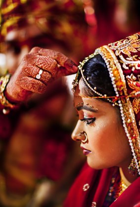 A groom puts 'sindoor' (holy red color) on the bride's forehead as per the wedding custom in Jodhpur, Rajasthan.