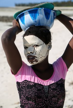 A young woman on Matemo Island's beach. Local women wear natural make-up to protect their skin from the sun. 