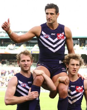 Champion effort: 350-game veteran Matthew Pavlich is chaired from the ground by David Mundy and Chris Mayne.