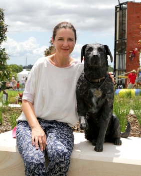 Brisbane sculptor Kathy McLay poses with her lifesize bronze statue of Sarbi, the former Australian Special Forces explosives detection dog at the opening of Sarbi Park at Warner Lakes.