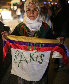 A woman holding a banner that reads in Turkish: 'Peace', celebrates election results of the pro-Kurdish Peoples's Democratic Party (HDP) in Diyarbakir, in Turkey's predominantly Kurdish south-east.