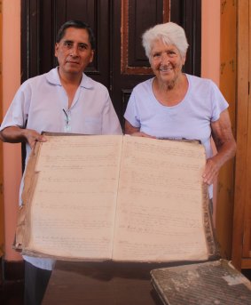 Dawn Fraser inspects an old military log book with an archive assistant.