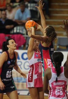 Bianca Chatfield looks on as teammate Geva Mentor goes up to try and block a shot by Erin Bell of the Queensland Firebirds.