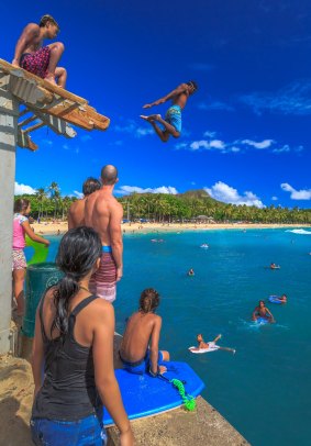 Jumping off Waikiki Pier between Kuhio Ponds and Queens Beach along Waikiki Beach.
