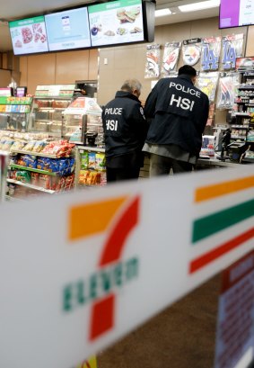 US Immigration and Customs Enforcement agents serve an employment audit notice at a 7-Eleven in Los Angeles. 