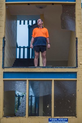 Sky View Units manager Shane Burling inspects the damage to his property of the forseshore of Bowen in the aftermath of Cyclone Debbie.