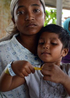 Mimi, a Rohingya mother from Myanmar and her daughter Asma rest at a confinement area in Langsa port, Aceh province.