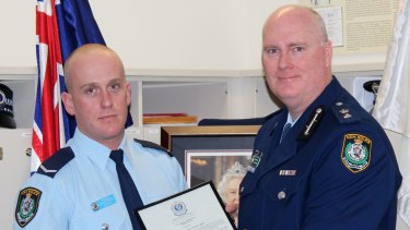 Chris Sheehy (left) receives a bravery award from Newtown Police Commander Simon Hardman in September 2015. The young officer was being covertly monitored during the same period on the recommendation of his boss. 