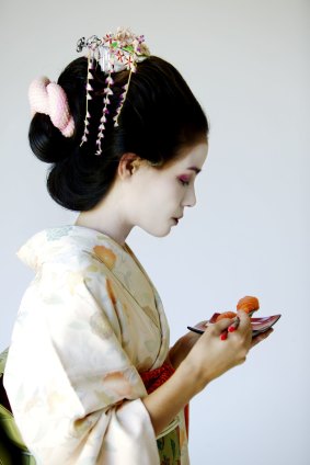 A traditional Japanese Maiko eating sushi.