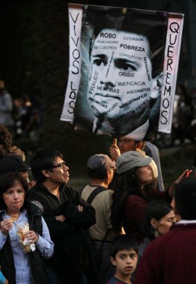 Demonstrators in Mexico City hold a picture of President Enrique Pena Nieto bearing the slogan "we want them alive".