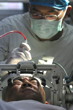 A doctor applies electric shocks on a drug addict's brain at a hospital in Xian, in China's Shaanxi Province Tuesday July 13, 2004. 