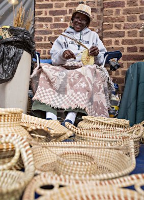 Gullah woman weaving sweetgrass baskets at the Historic Charleston City Market.